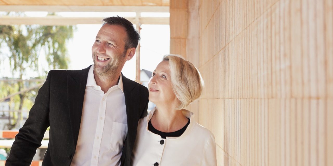 Happy couple inside unfinished building surrounded by bare brickwork