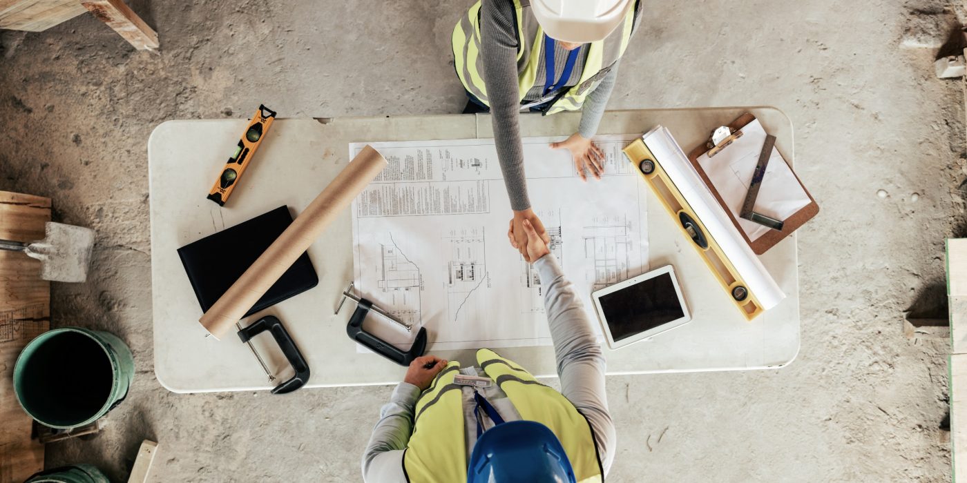 Architect, handshake and thank you for construction, blueprint and collaboration on building design.