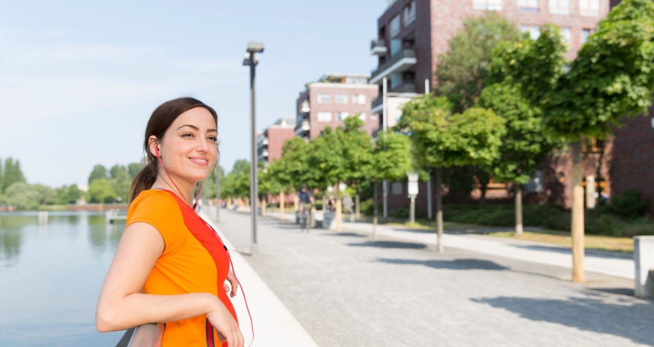 Female jogger relaxing on the waterfront in urban environment