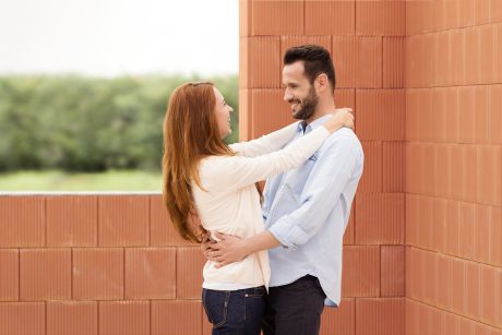 Man and woman celebrating their future home inside building shell